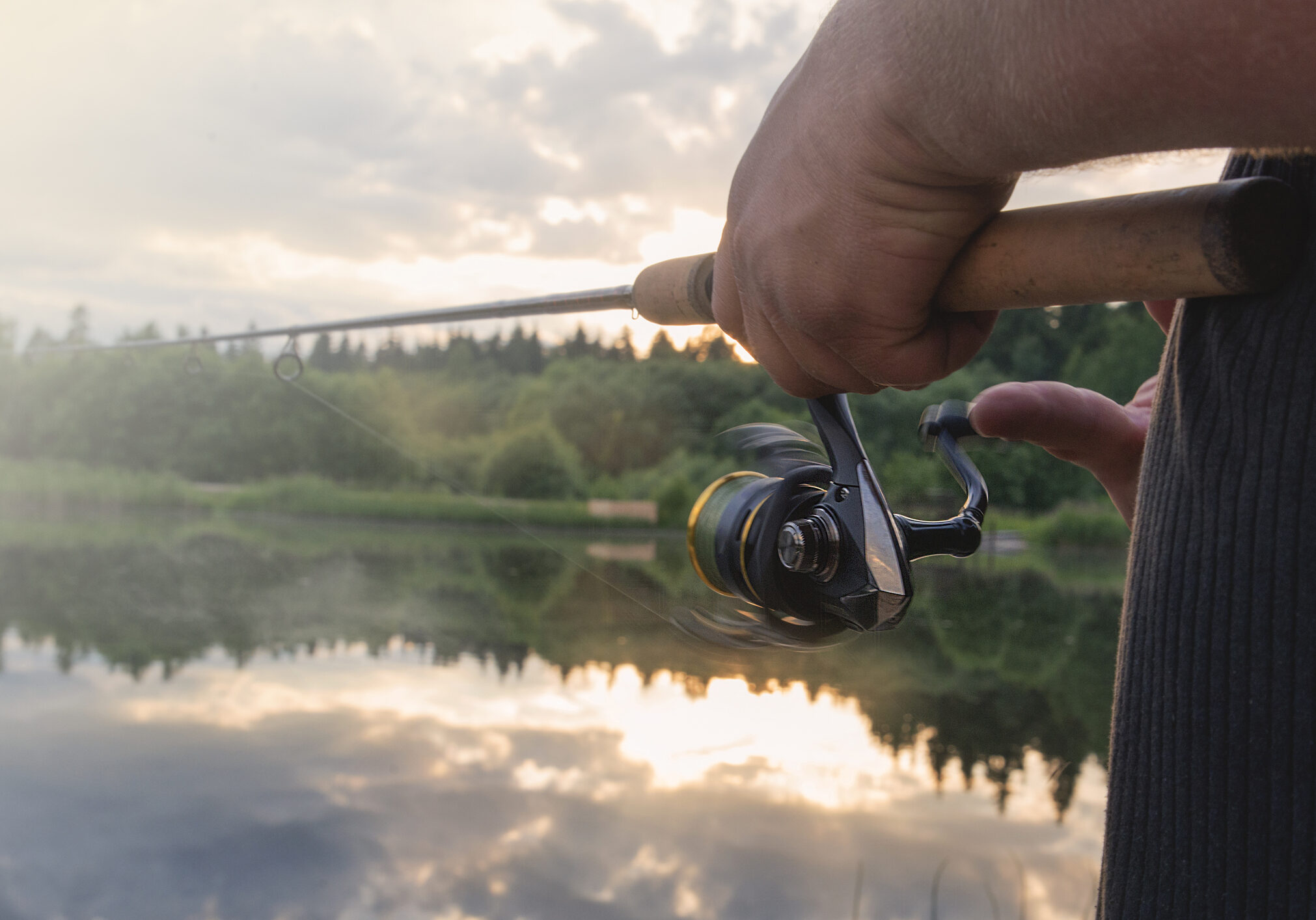 The man catches a fishing-rod fish on a reservoir.